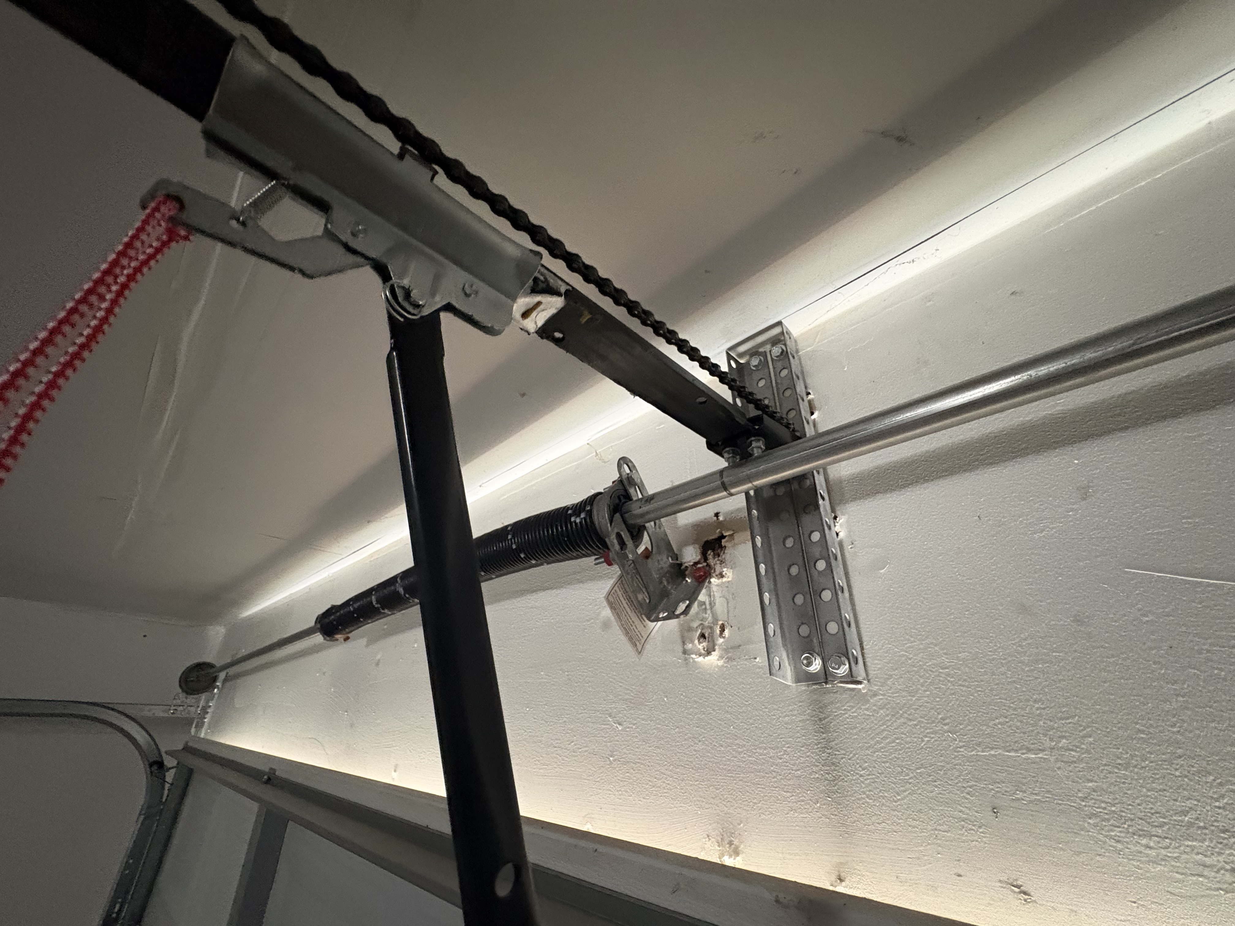 Garage door center bearing bracket detached from wall in Austin TX torsion bar sagging dangerously