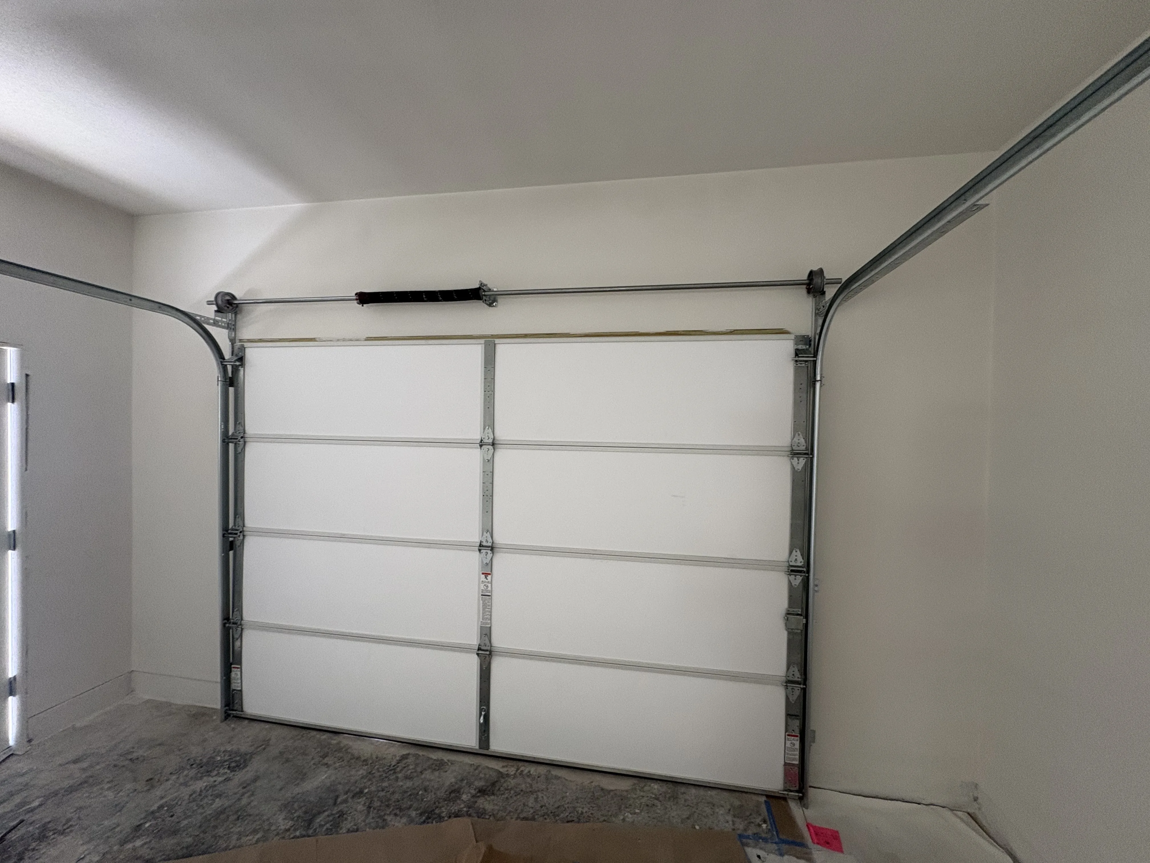 After - new white insulated garage door installed interior view