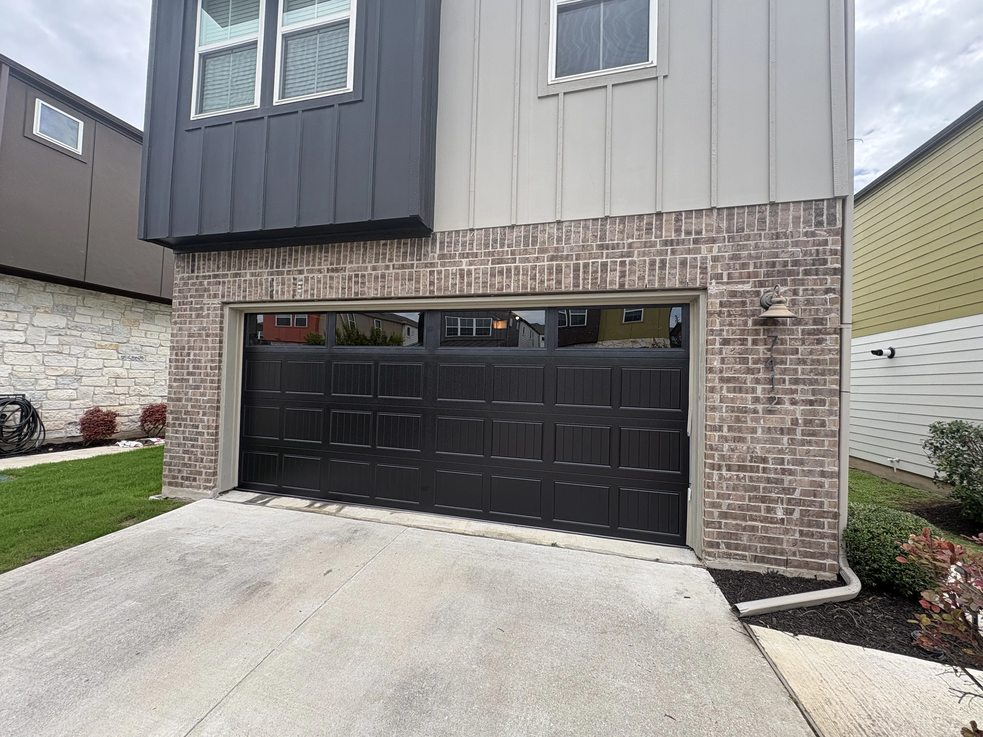 After - new black carriage style garage door with windows exterior view