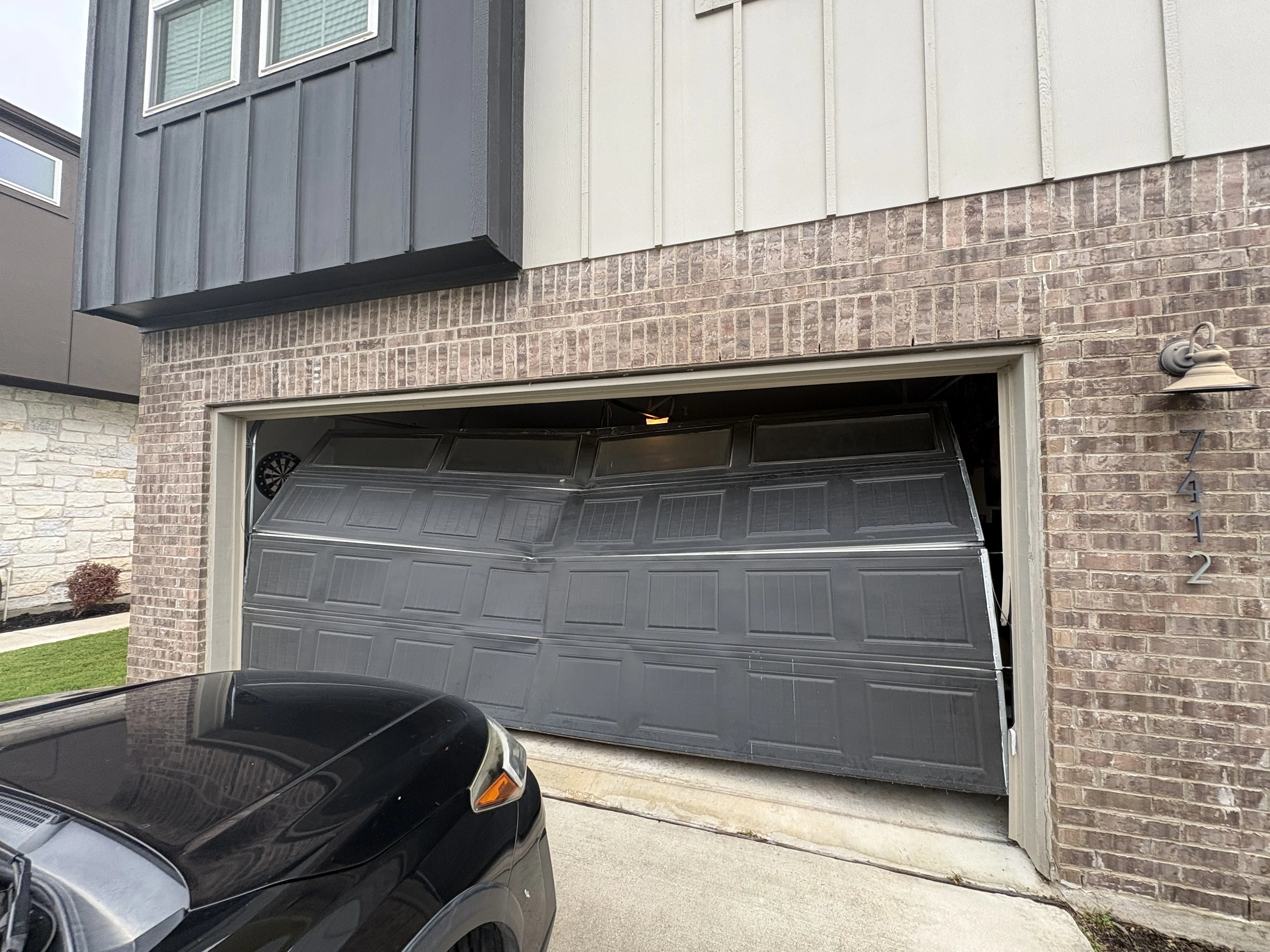 Before - severely damaged garage door exterior Easton Park Austin TX